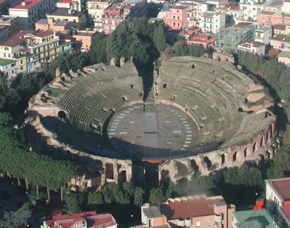 Aerial view of ancient Herculaneum amphitheatre ruins surrounded by modern Ercolano buildings on a private half-day tour