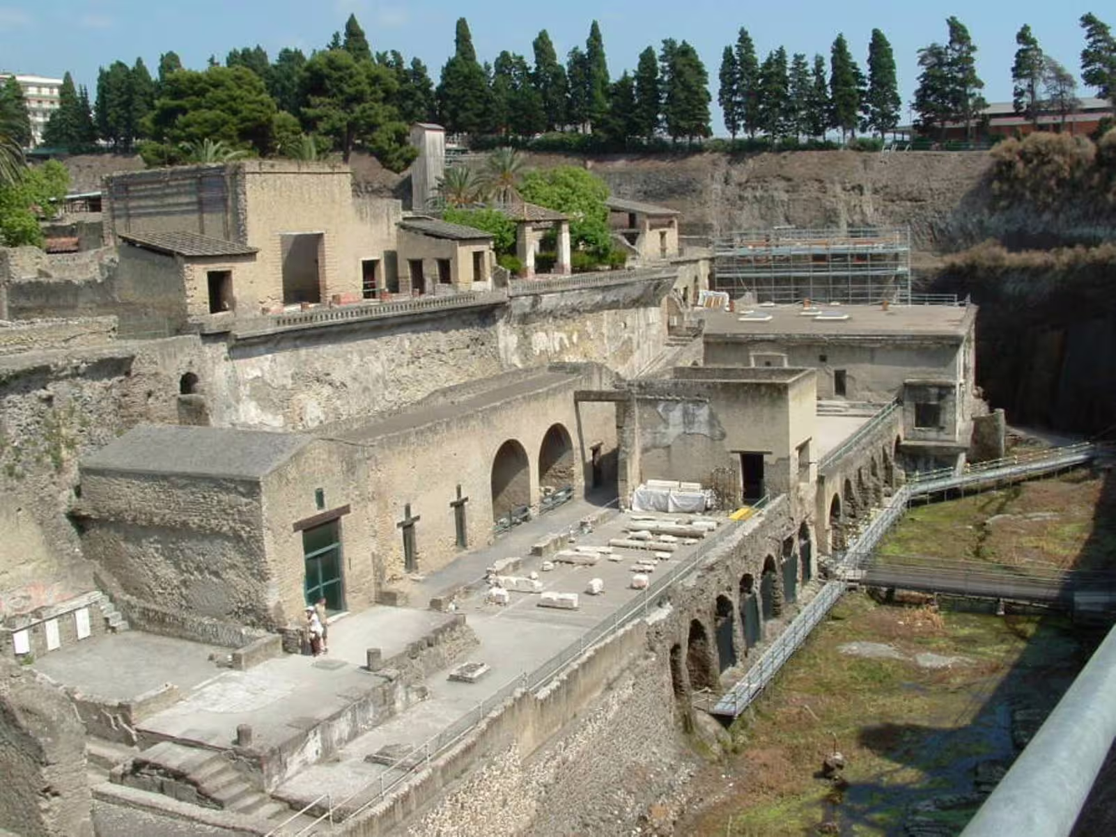 Visitors exploring the excavated ruins of ancient Herculaneum near Pompeii on a shared Positano and Pompei archaeological tour