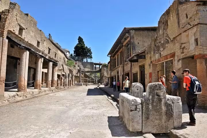 Visitors exploring the well-preserved streets of Herculaneum, ideal for a skip-the-line experience with easy lunch.