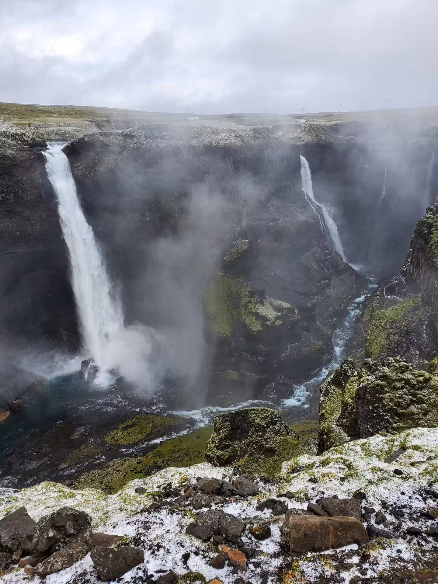 Aerial view of a powerful hidden waterfall cascading down misty volcanic cliffs on a private super jeep Iceland day trip