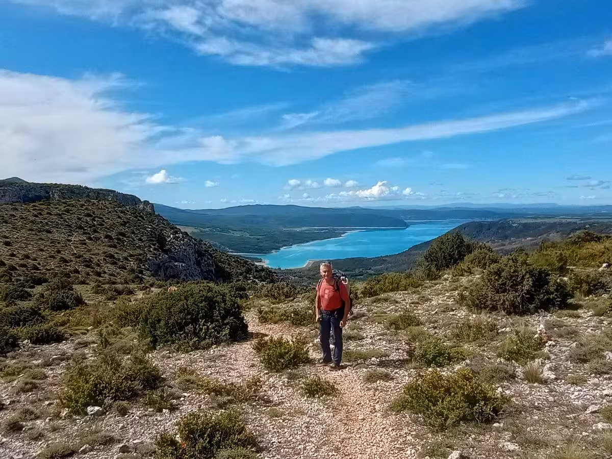 Hiker on rocky trail above Lac de Sainte-Croix, Verdon Gorge 6-day guided hike in Provence, France
