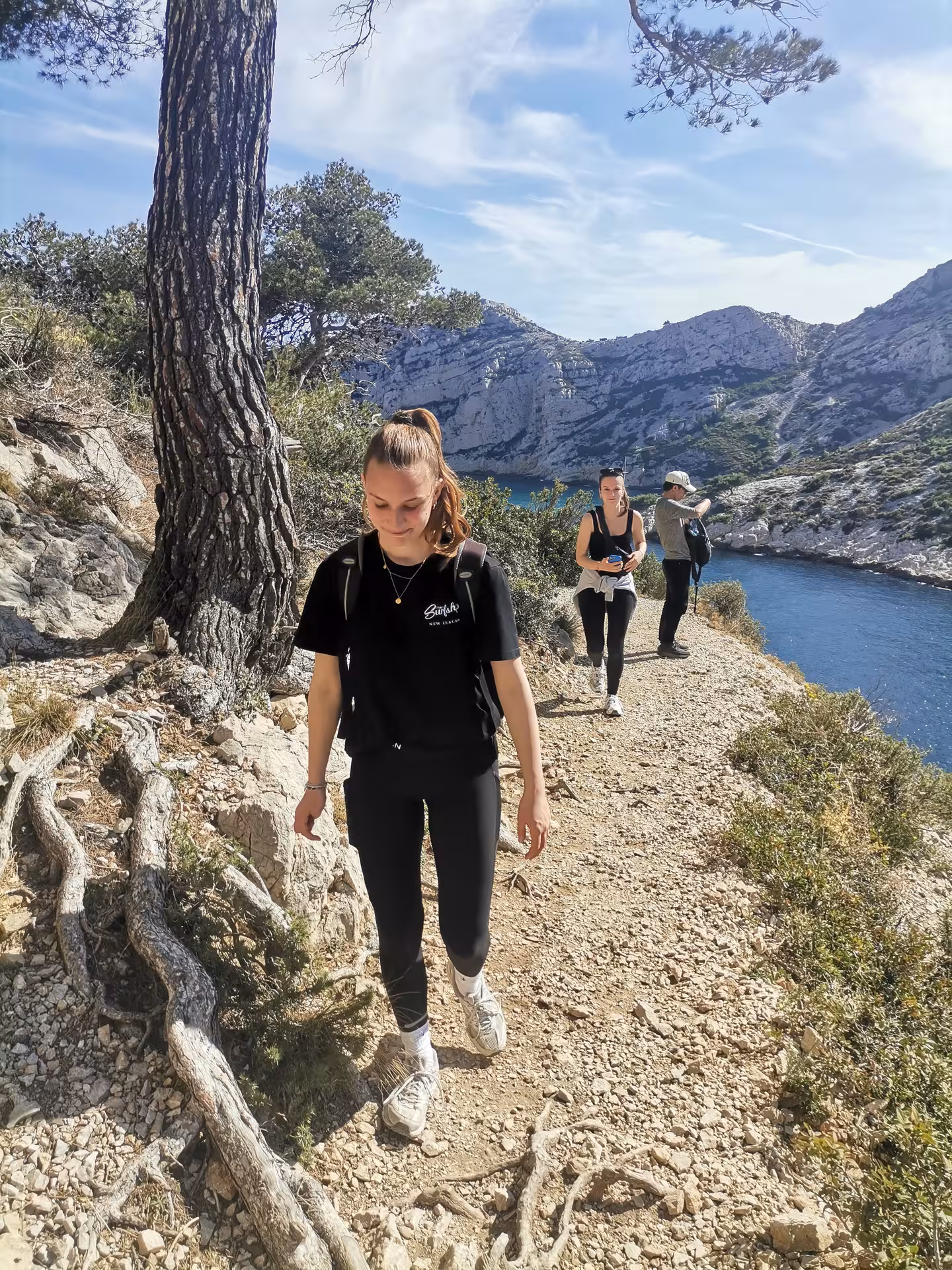 Hikers on coastal trail above turquoise Calanques near Marseille on 11-day Provence hiking getaway