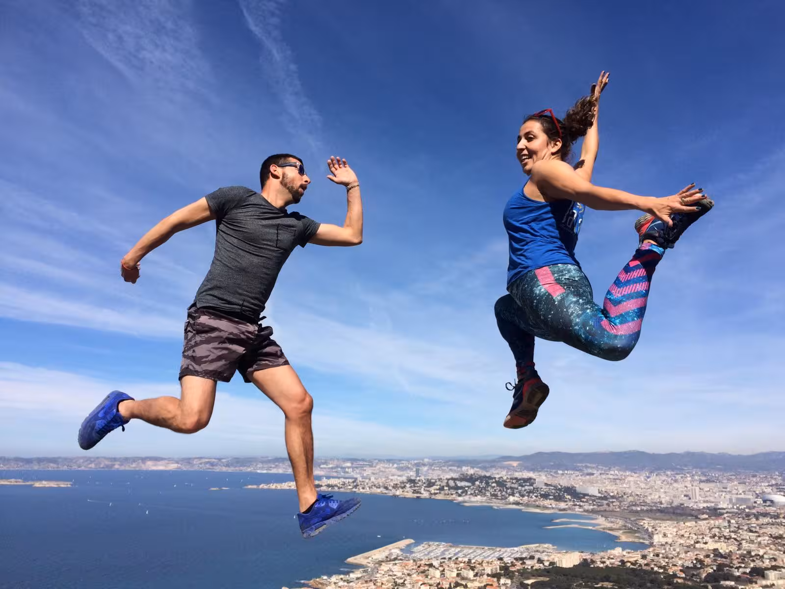 Hikers jumping on a Provençal coastal viewpoint above Marseille, fun moment on the 7-day Calanques trek