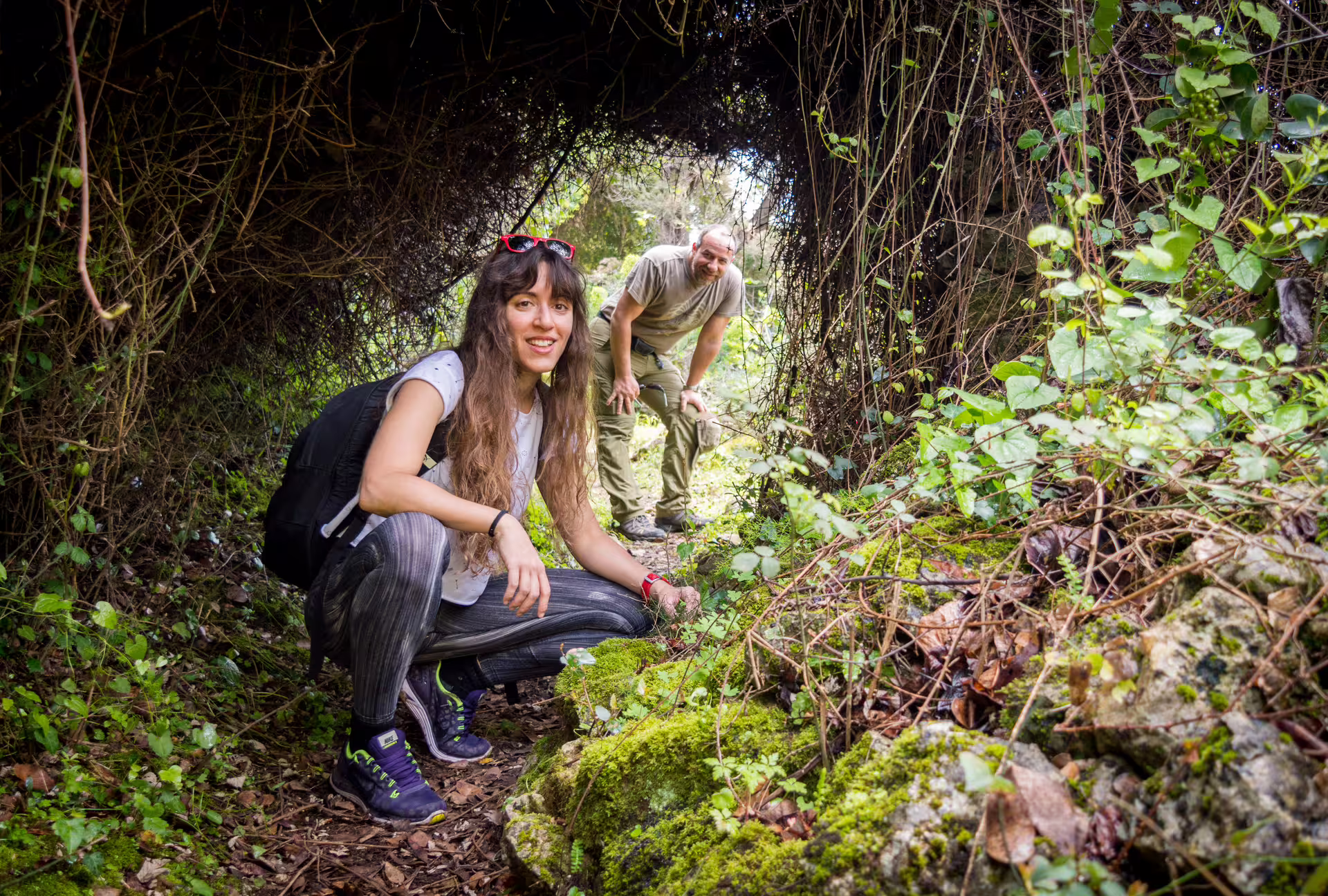 Hikers exploring a leafy tunnel on a Kardamyli guided hike, discovering Mani nature trails and springs