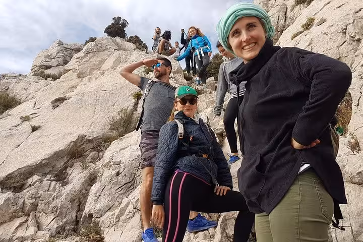 Hikers posing on white limestone cliffs during Les Calanques panoramic hike, guided Marseille outdoor adventure
