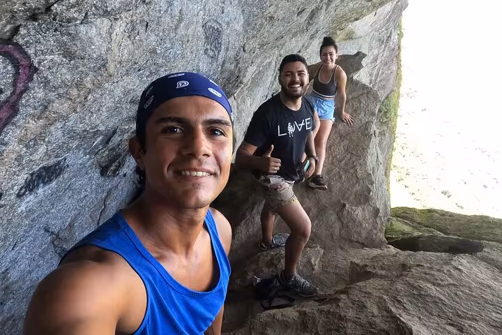 Hikers posing on a rocky cliff during the Garganta do Céu adventure hike in Pedra da Gávea.