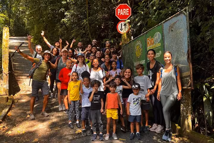 Group of diverse hikers smiling at the entrance of a trail in Tijuca Forest, ready for an adventurous trek.