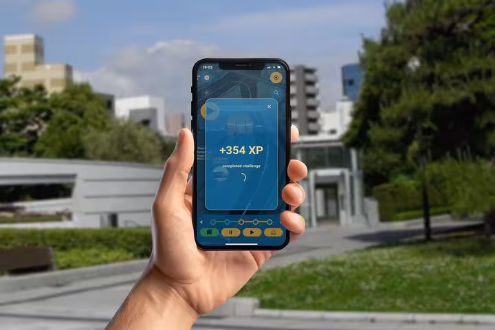 Hand holding smartphone showing +354 XP completed challenge screen on Hiroshima self-guided walking tour app