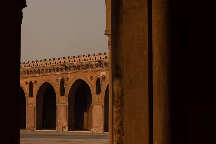 Sunlit courtyard arches of a historic Cairo mosque, Old Cairo Islamic monuments and mosque tour experience