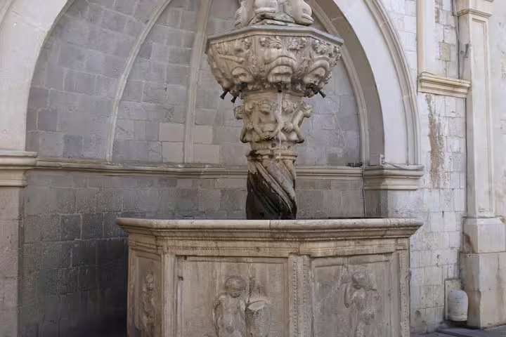 Historic stone fountain in Old Town courtyard, a highlight stop on the Discover the Old Town Walking Tour