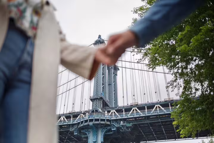 Holding hands under Manhattan Bridge, a highlight of a personalized New York travel photography tour.