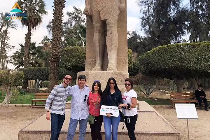 Group photo by ancient statue in Cairo park, part of the 15 Days 14 Nights Holy Family Tour in Egypt