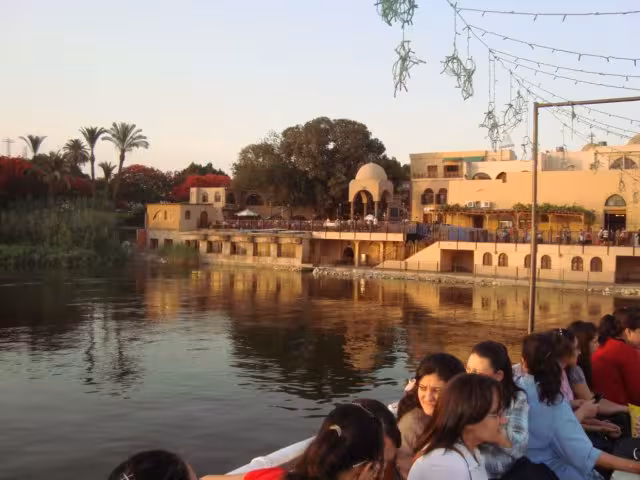 Nile riverside view at sunset with travelers, a highlight of The Holy Family Trip Egypt pilgrimage tour
