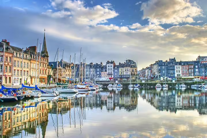Honfleur harbor with sailboats and colorful waterfront houses, scenic stop on a private tour from Paris to Normandy