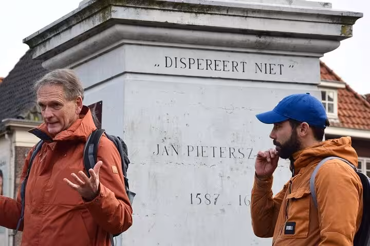 Guide explains Jan Pietersz monument in Hoorn during a 2-hour walking tour of history and highlights