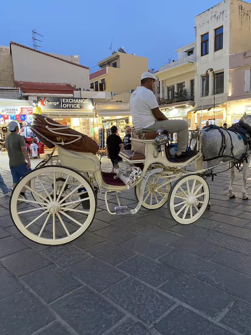 Horse-drawn carriage in Chania's vibrant evening market on a semi-private Aptera & Chania tour.