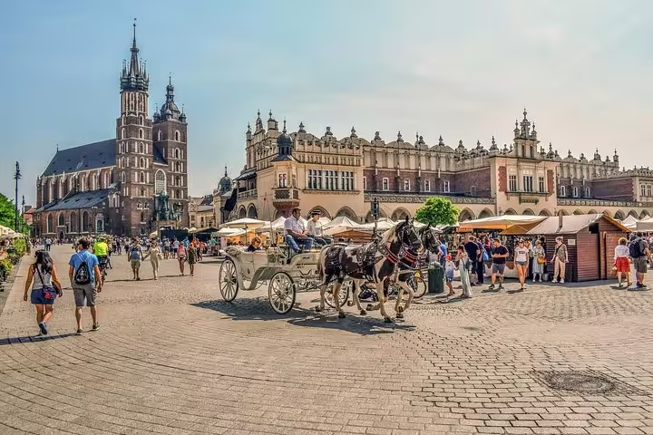 Horse-drawn carriage on Krakow Main Market Square with Cloth Hall and St. Mary’s Basilica, private tour