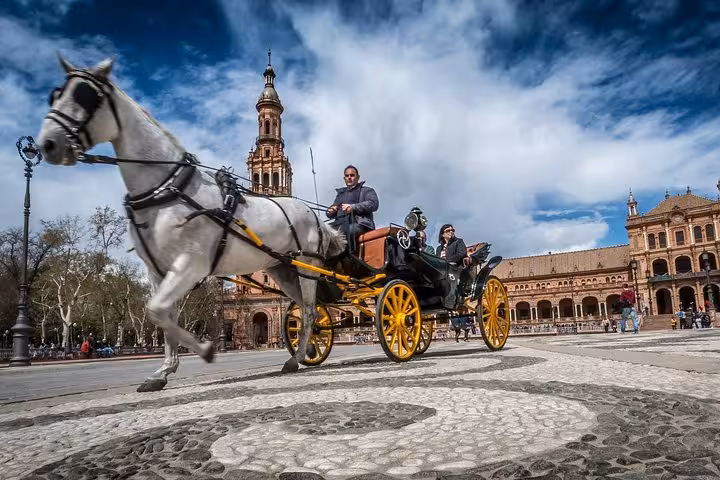 Horse-drawn carriage ride in Seville's Plaza de España, capturing traditional charm on the Andalusia & Madrid guided tour.