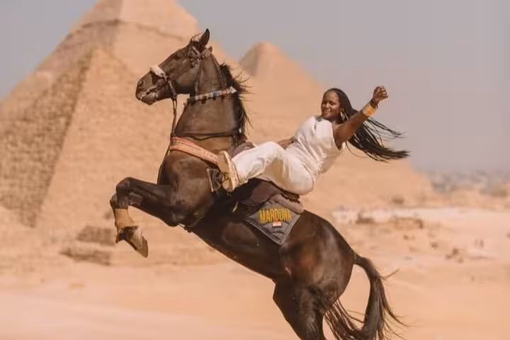Horse jump photo experience at Giza Pyramids, rider posing on rearing horse with pyramids in background
