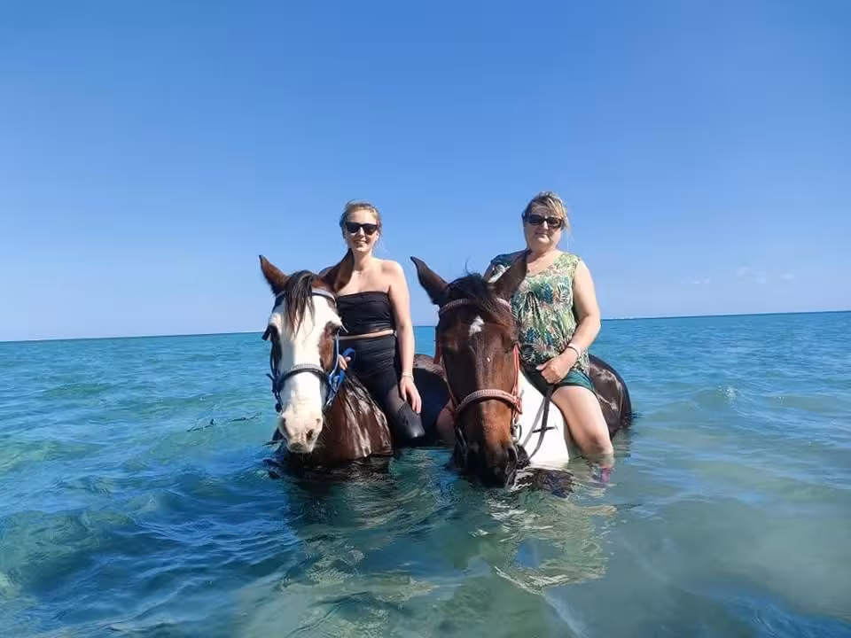 Two women on horses in shallow Red Sea water, Hurghada sea riding experience on 2-hour desert and beach tour