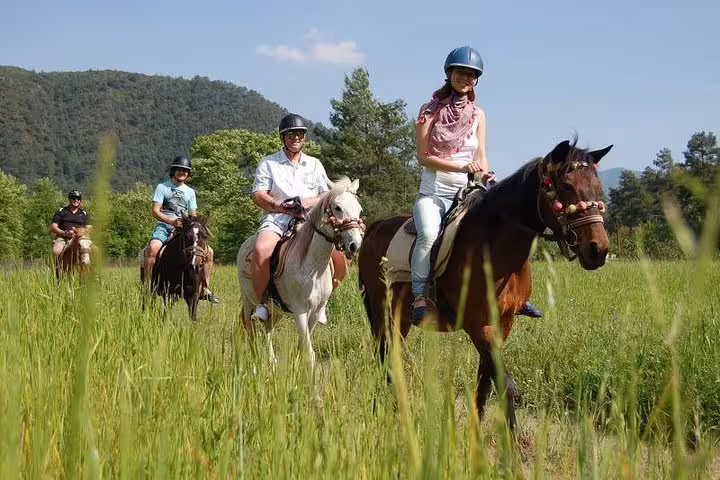 Group of tourists on a scenic horseback ride through lush fields near Kusadasi Port, ideal for cruise visitors.