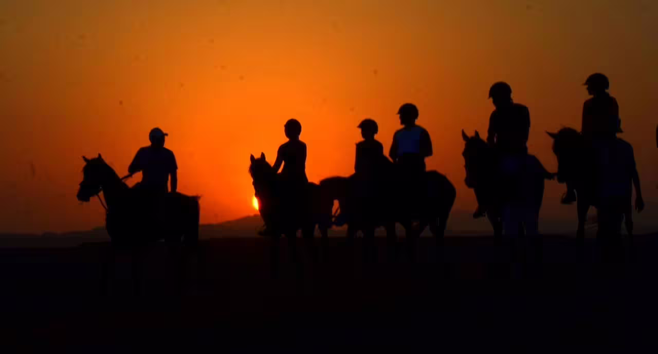 Silhouetted riders on a Marsa Alam desert horseback ride at sunset, Red Sea Egypt evening tour