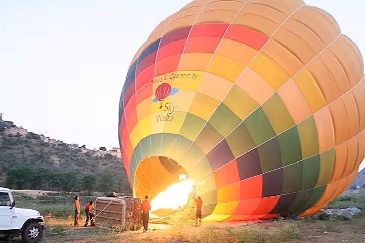 Crew inflating colorful hot air balloon in Luxor for sunrise flight on private Luxor overnight tour from Hurghada