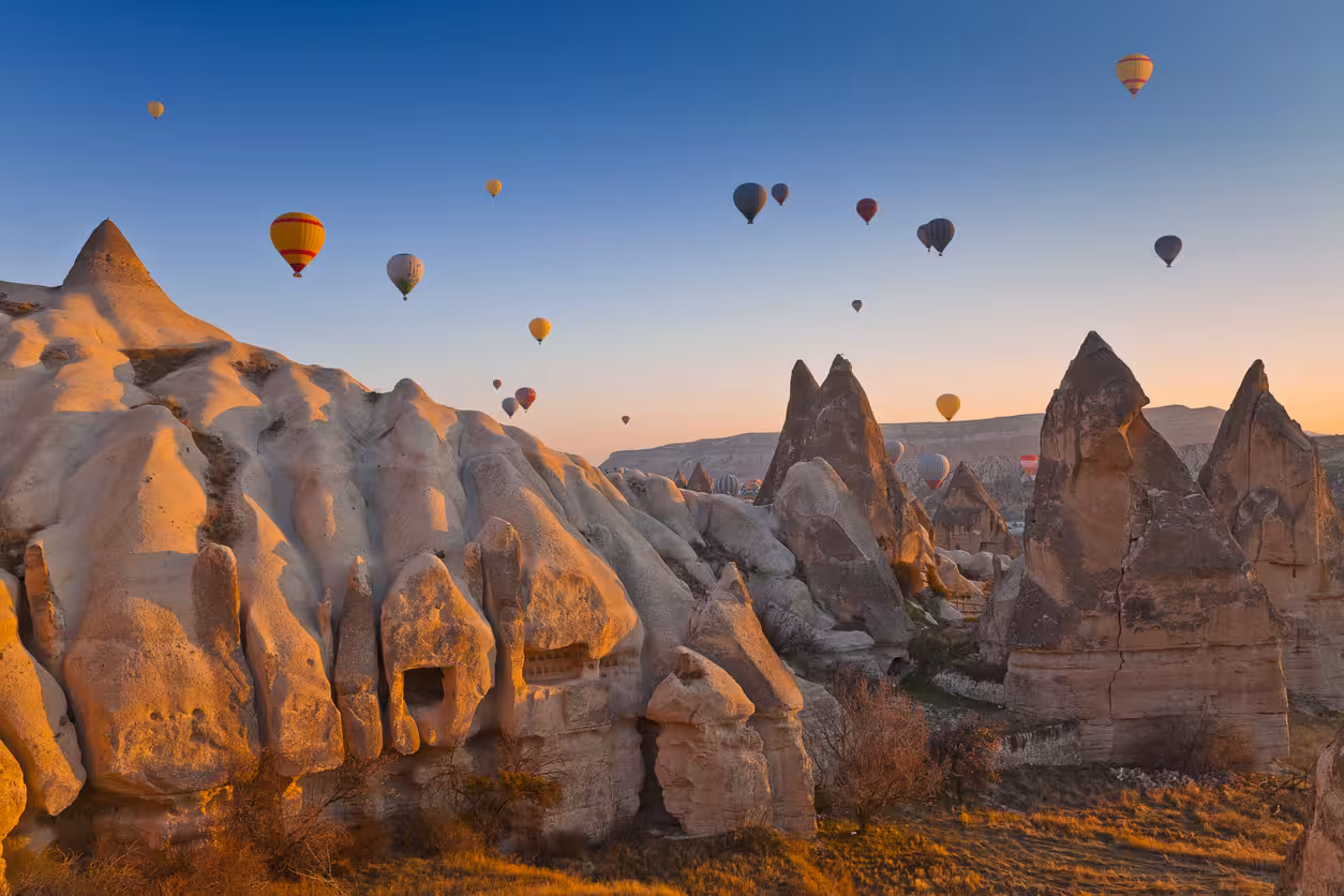 Hot air balloons over Cappadocia fairy chimneys at sunrise