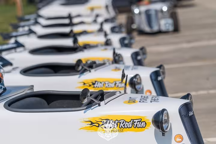 Row of white Hot Rod Fun cars lined up for a guided city tour experience