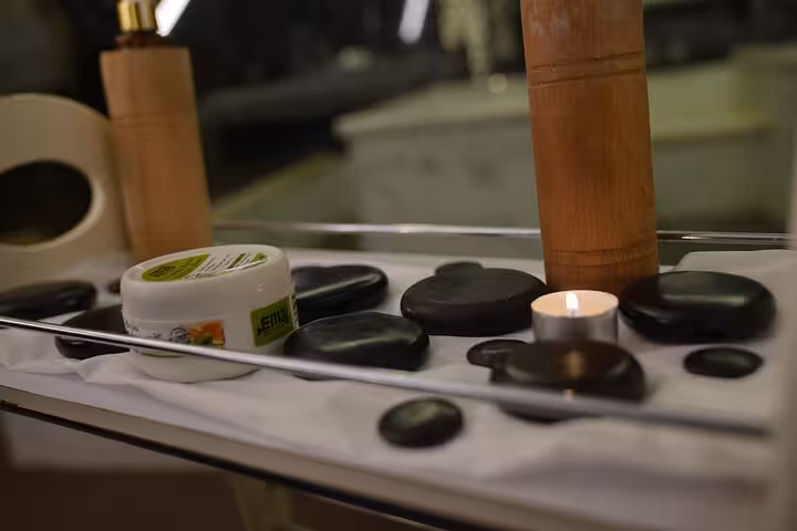 Hot stone massage setup with candle, oils and basalt stones for VIP solo massage experience in Sharm El Sheikh