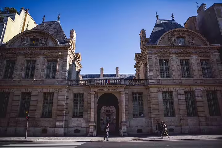Hôtel de Sully historic mansion facade in Le Marais district, Paris, with ornate stonework and arched gateway