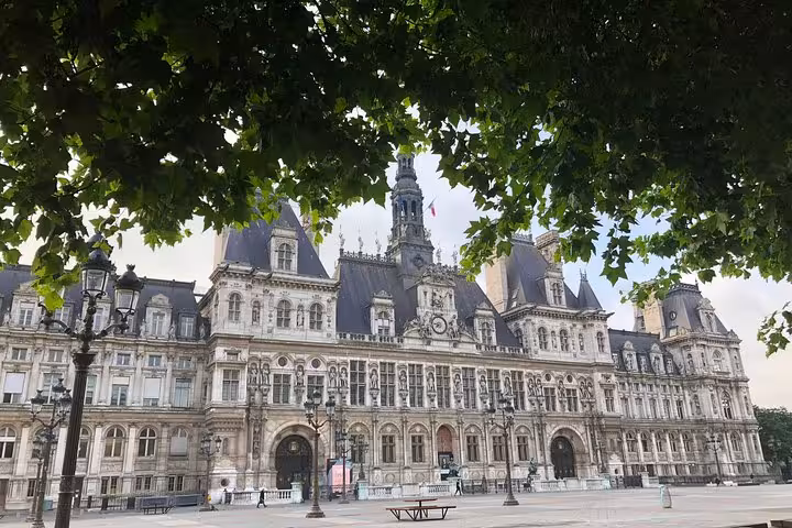Hôtel de Ville Paris city hall ornate Renaissance facade framed by green tree branches in open square
