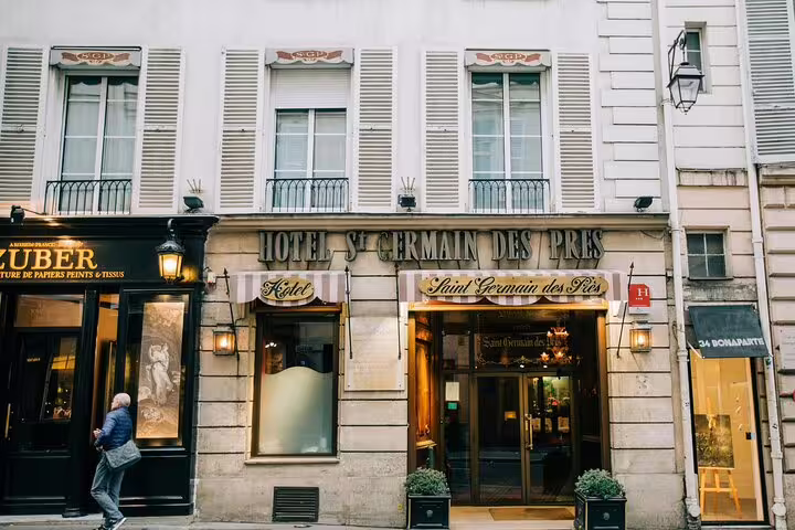 Elegant facade of Hotel Saint Germain des Prés in Paris with classic shuttered windows and warm entrance lighting