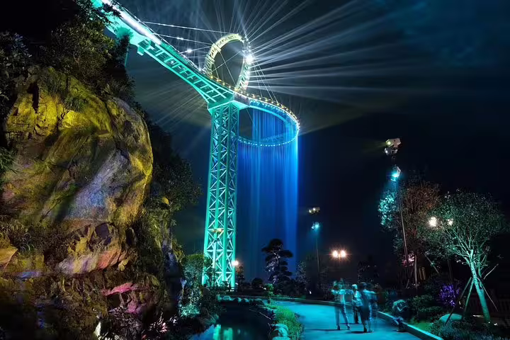 Experience the breathtaking Huangteng Canyon Skywalk illuminated at night with vibrant lights, perfect for a Guangzhou tour.