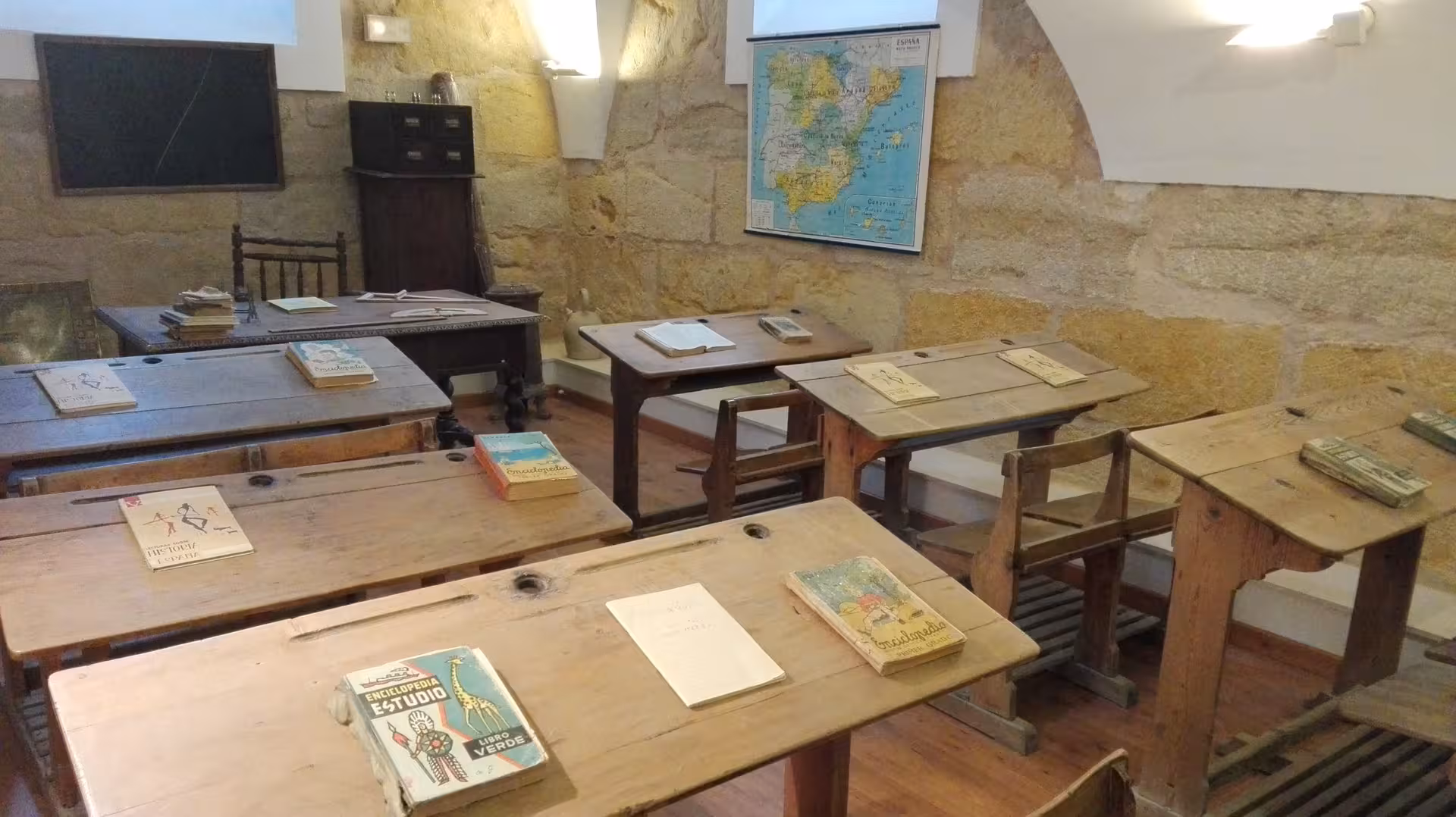 Recreación de escuela histórica en Huete con libros y pupitres, visita cultural de la Ruta Etnográfica de Huete