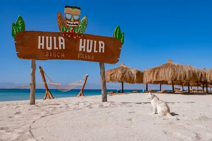 Hula Hula Beach Island sign on white sand with hammocks and cabanas, Red Sea lunch and water sports tour