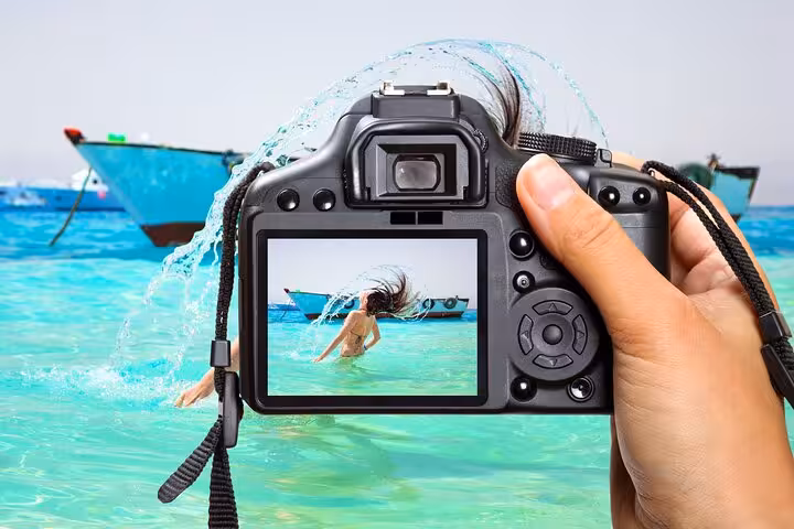 Camera capturing swimmer in crystal-clear Red Sea at Hula Hula Island, Hurghada tour with lunch and water sports
