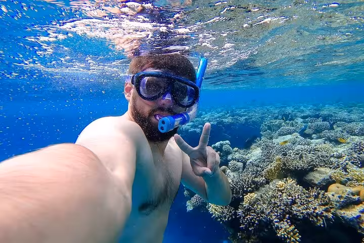 Snorkeling selfie over vibrant coral reef on Hula Hula Island tour with lunch and water sports adventure