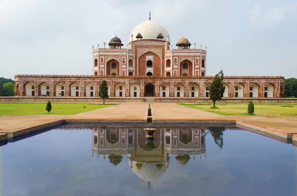 Humayun's Tomb reflected in a serene water pool, a highlight of Delhi's heritage on the Golden Triangle tour.