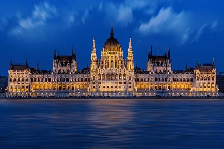 Hungarian Parliament Building lit at night on Danube, highlight of Budapest private day tour from Vienna