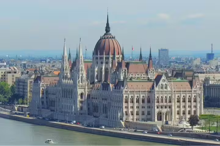 Stunning view of the Hungarian Parliament Building along the Danube River, a highlight of the Private Budapest Day Trip from Vienna.