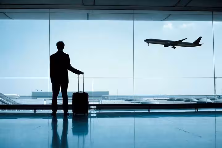 Traveler with suitcase at airport window, ideal for Hurghada Airport to hotel private transfer with meet and greet