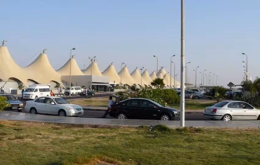 Hurghada International Airport exterior with cars, ideal for booking private airport transfer to hotels