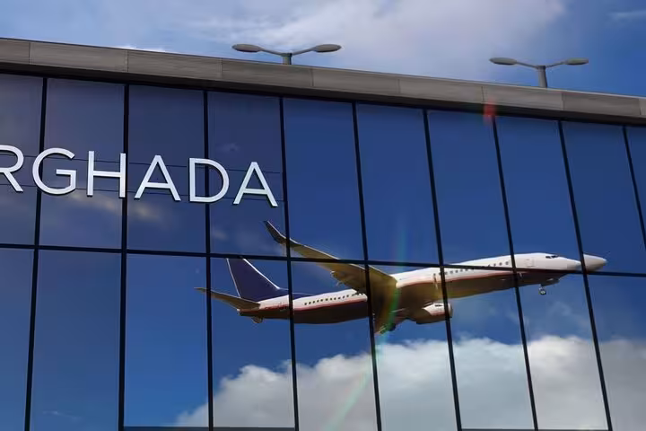 Hurghada Airport terminal glass facade with airplane reflection, ideal for meet and greet private transfer