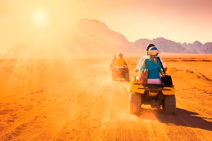 Riders on ATVs at sunset in Hurghada desert, quad bike safari with hotel transfer and BBQ dinner