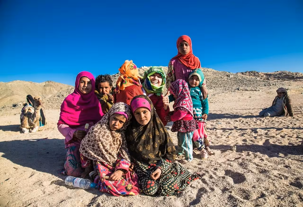Bedouin children in colorful scarves in Hurghada desert, a cultural stop on ATV quad safari and camel ride tour