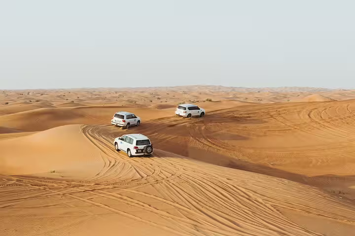 4x4 jeeps crossing golden dunes on Hurghada Bedouin desert safari, with quad bike ride, camel and dinner