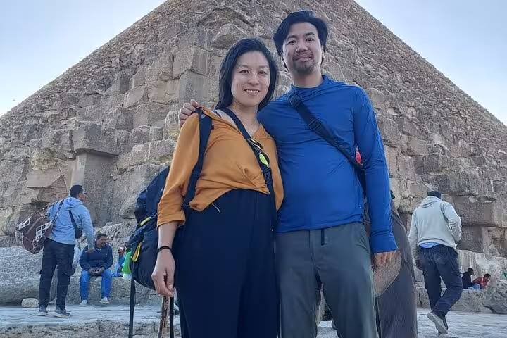 Couple posing by the Great Pyramid of Giza on Hurghada to Cairo day tour with Grand Egyptian Museum visit