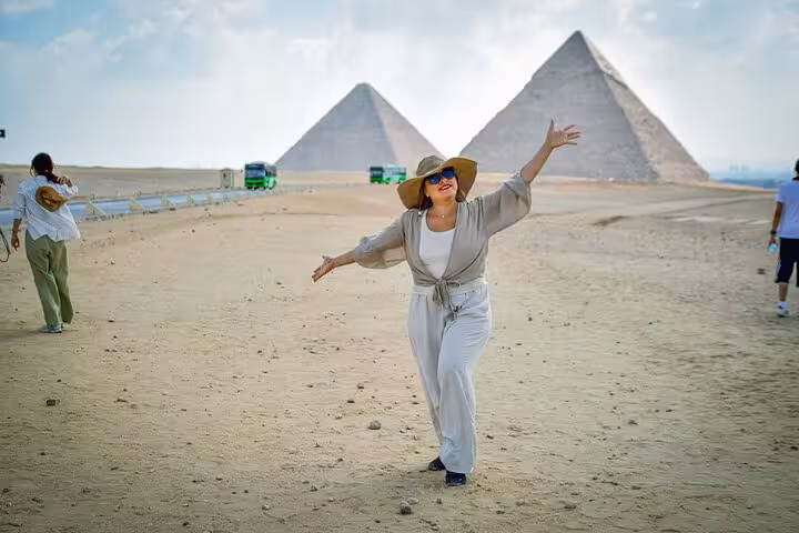 First-time Cairo day trip from Hurghada with traveler posing at the Giza Pyramids in the desert