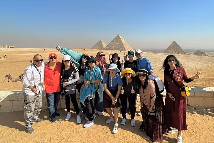 Tour group posing at Giza Pyramids on full-day Hurghada to Cairo pyramids and museum day trip